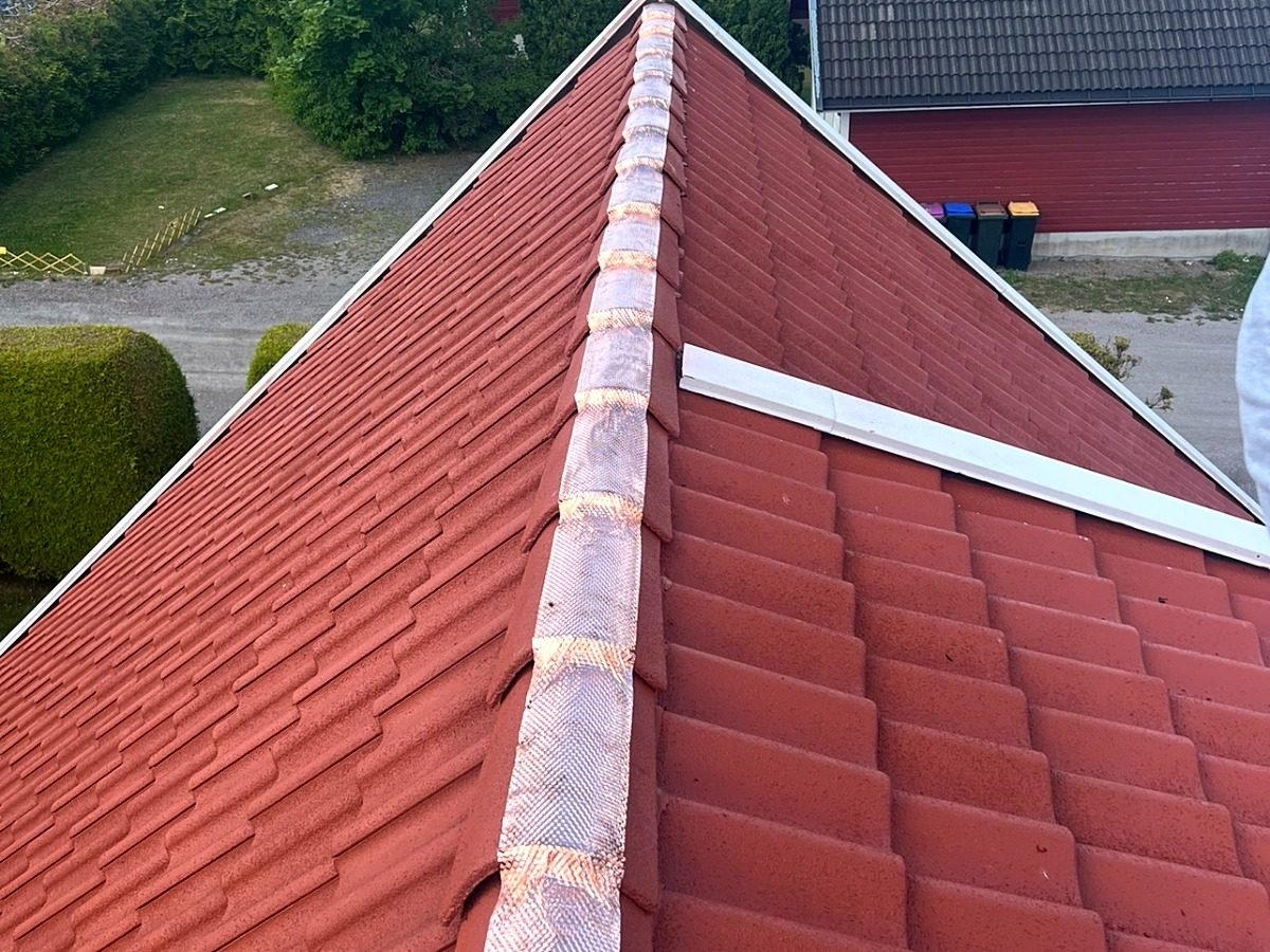 Kobberbånd montert på nymalt rødt tak